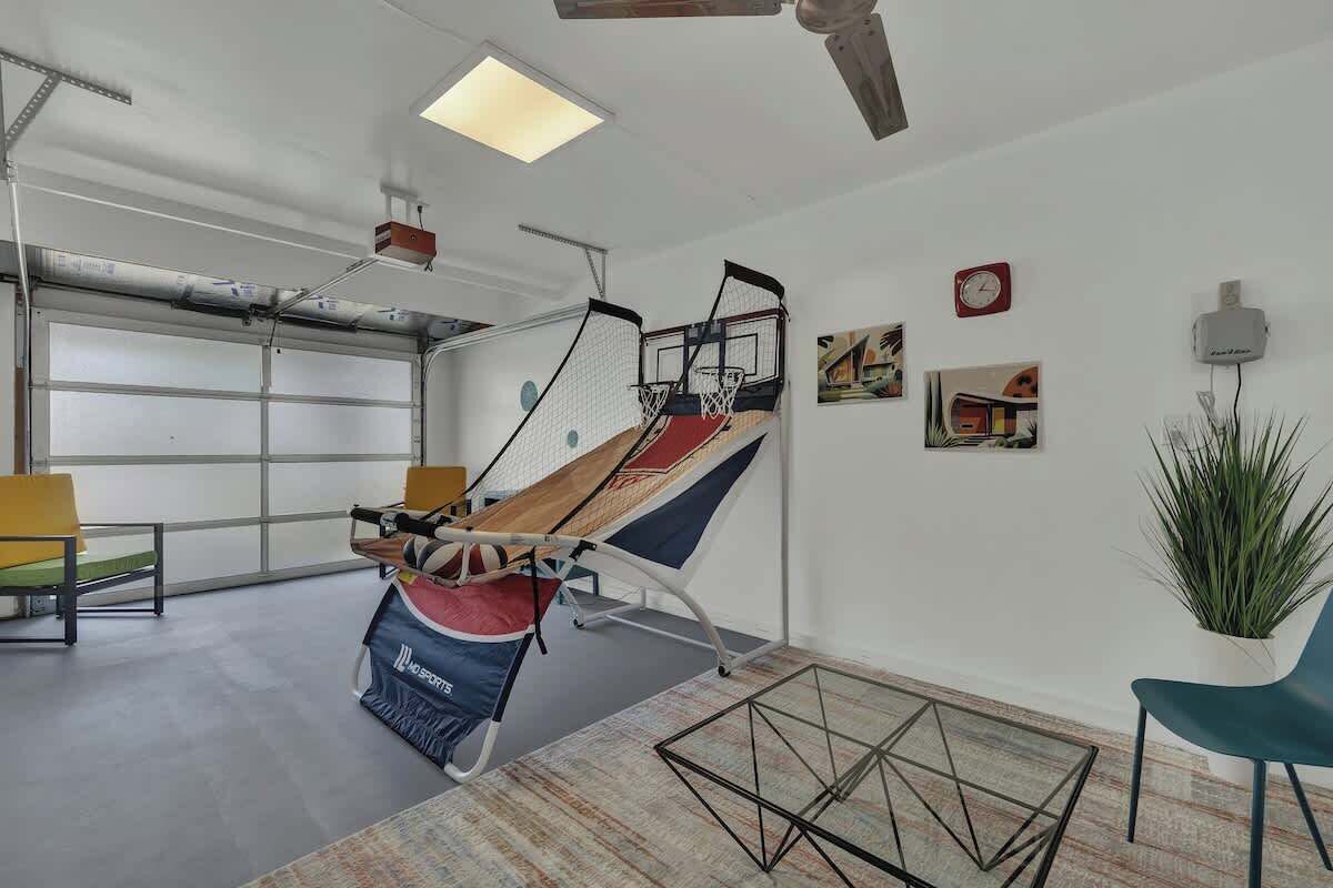 A room with a basketball hoop, a large window, and a potted plant.