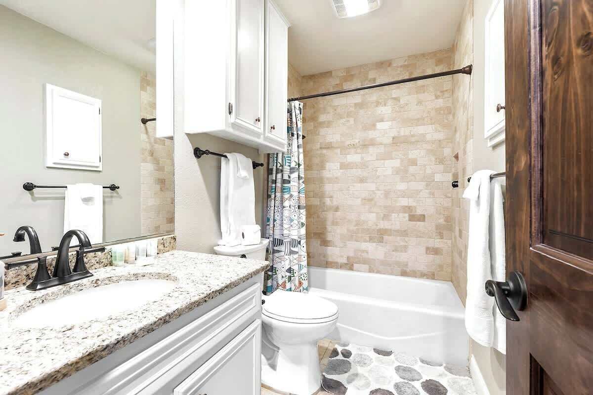 Un baño con bañera, inodoro y lavamanos.