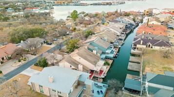 Un barrio residencial con casas a lo largo de un río, un muelle y una vista despejada del agua.