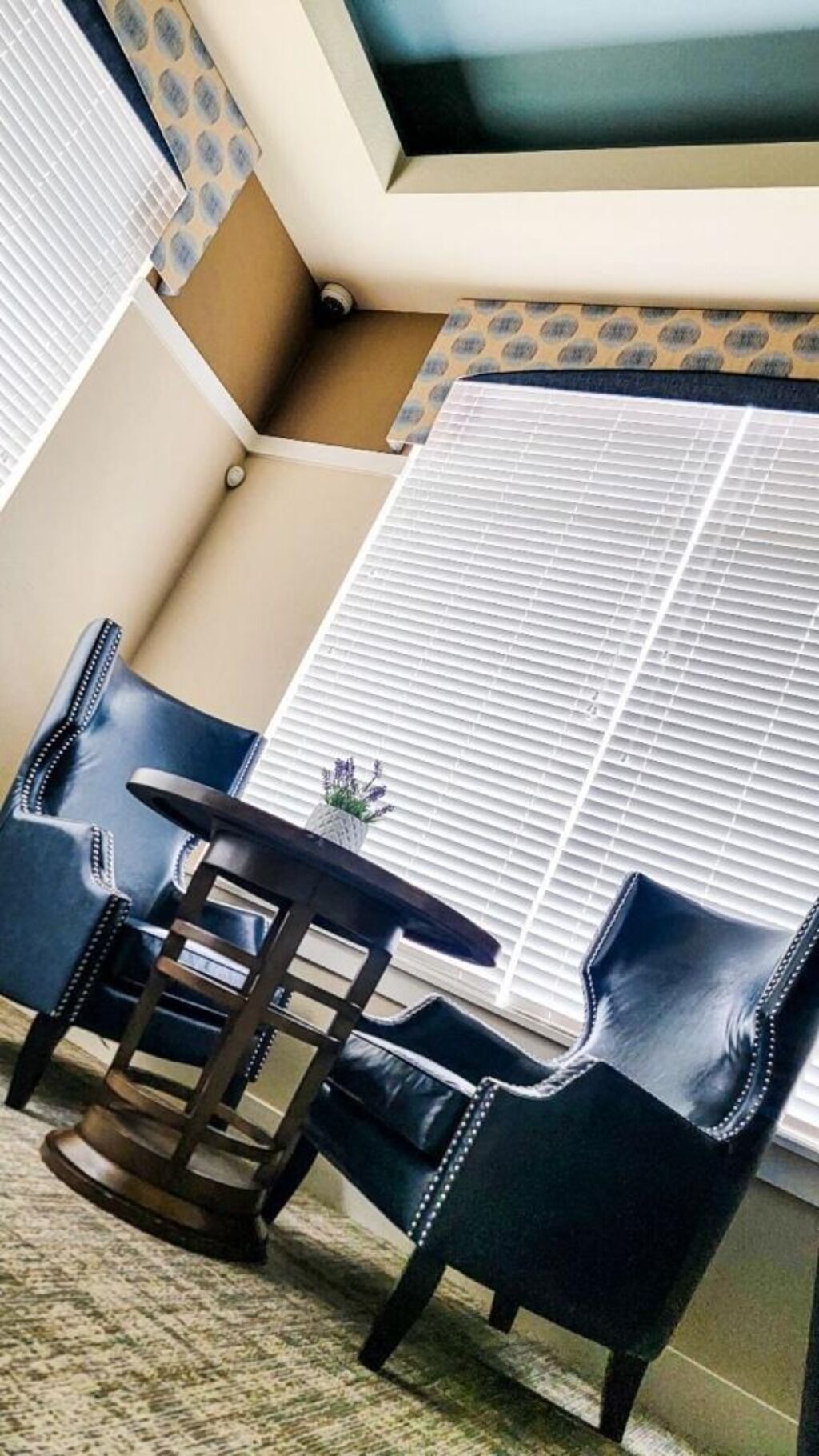 A corner room with a window, a table, and two chairs.