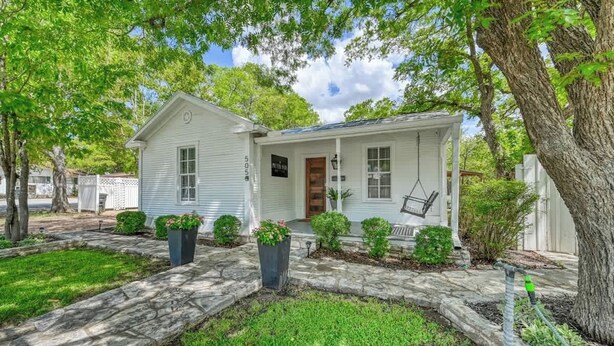 A single-story house with a front porch, a small attached garage, and a mailbox. - Charming Cottage Near Main With Patio&firepit!! (Fredericksburg)