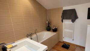 A bathroom with a bathtub, a white sink, a towel rack, and a radiator. - A 5mn de la mer et du Bourg ,une Villa Plain Pied Vous Attend ! (Préfailles)