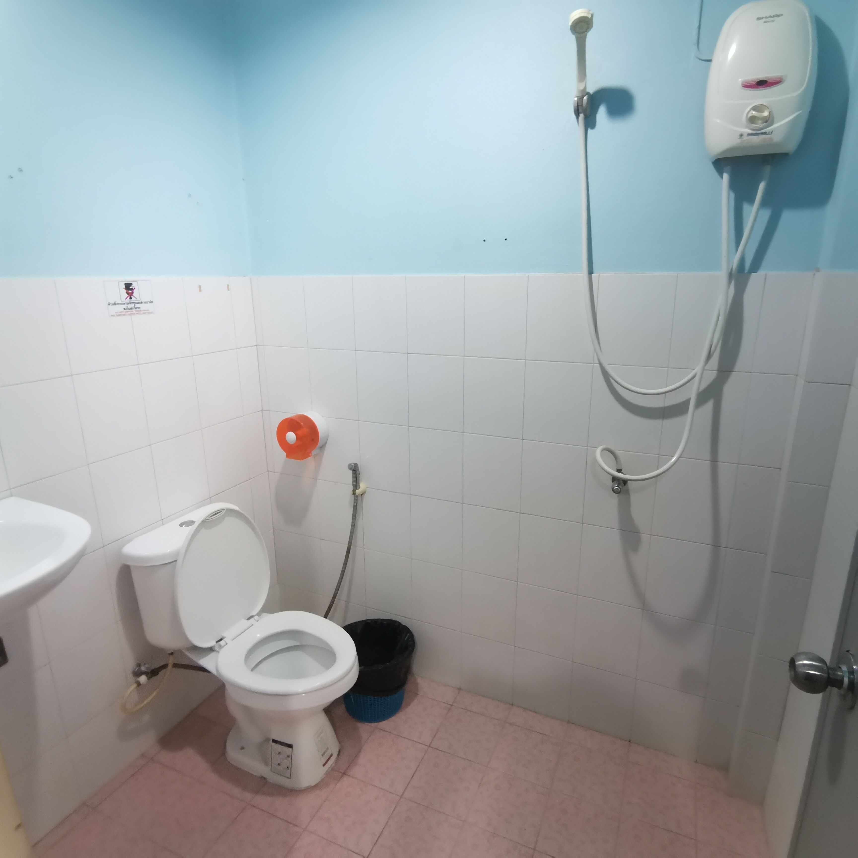 Un baño pequeño con inodoro, lavamanos y ducha.
