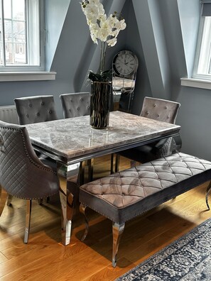A dining area with a marble table, tufted chairs, and a bench. - Immaculate 1-bed Apartment in Chelsea London (London)