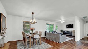 A spacious living area with a dining table, sofa, and TV. - Gorgeous Bluebonnet House With Deck and Fire Pit (Fredericksburg)