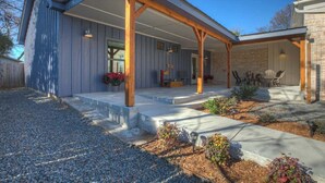 A covered patio area with a stone pathway leading to a seating area.