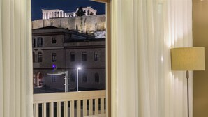Ein Balkon mit Blick auf altehrwürdige Architektur, eine Lampe und ein Straßenlaterne.