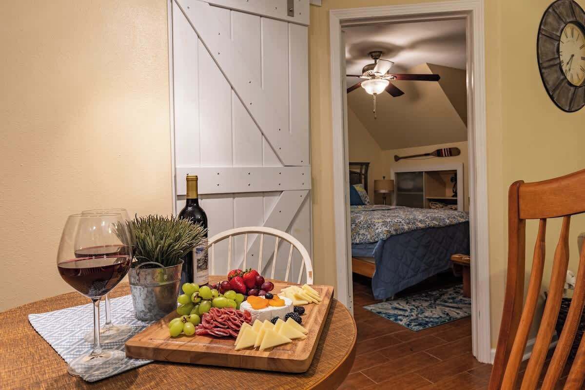 Ein Zimmer mit einem Bett, einem Deckenventilator und einem Holzstuhl.
