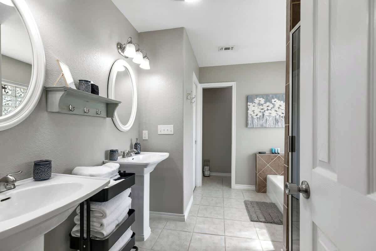 Une salle de bain moderne avec deux lavabos, un meuble-lavabo et un grand miroir.