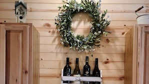 Una cocina con armarios de madera, un lavamanos blanco y una vinoteca con botellas y copas.