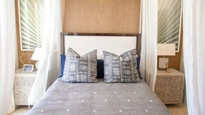 A neatly arranged bedroom with a bed, two bedside tables, and a canopy.