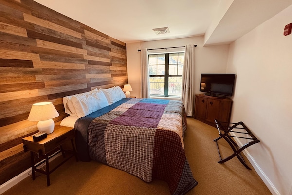 Newly decorated bedroom with king bed and mtn views of the slopes. New faux wood walls, designer quilt, lamps, night stands, makes this BR shine!