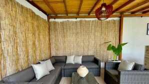 A room with a large sectional sofa, a small table, and a potted plant. - Casa de la Belleza, Uniquely designed 7 bedroom home (Cartagena de Indias)