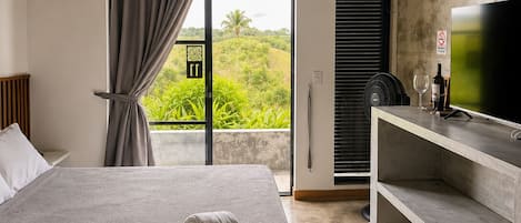A modern bedroom with a bed, a desk, and a television.