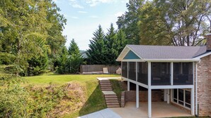 Een huis met twee verdiepingen, een overdekte patio en een gevel van baksteen.