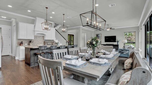 A spacious dining area with a long table set for a meal, surrounded by chairs.