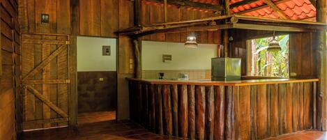 Una cocina rústica con paredes de madera y suelo de baldosas rojas.