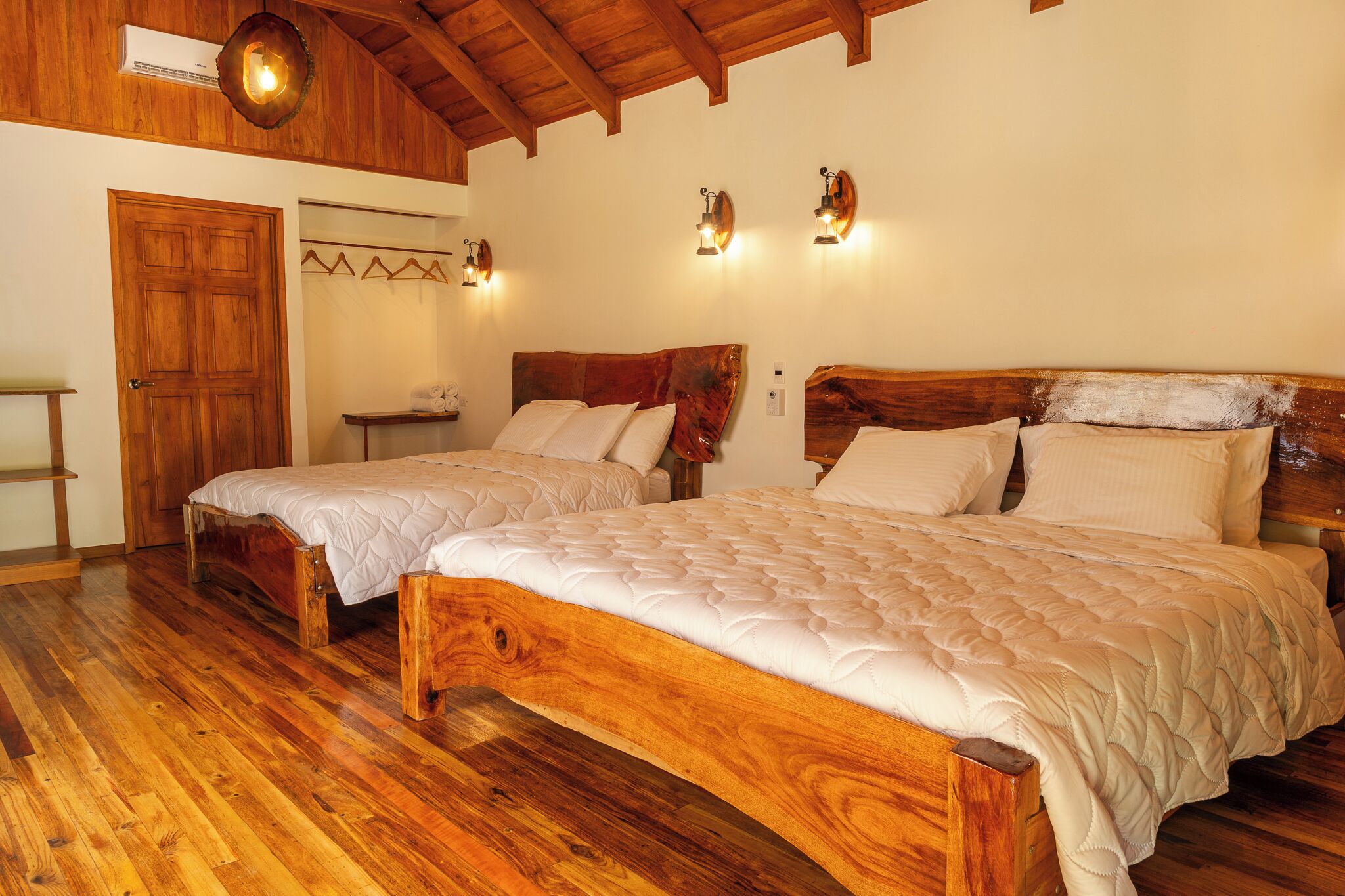 Ein Schlafzimmer mit zwei hölzernen Betten, einer Holzbalkendecke und einem Holzboden.