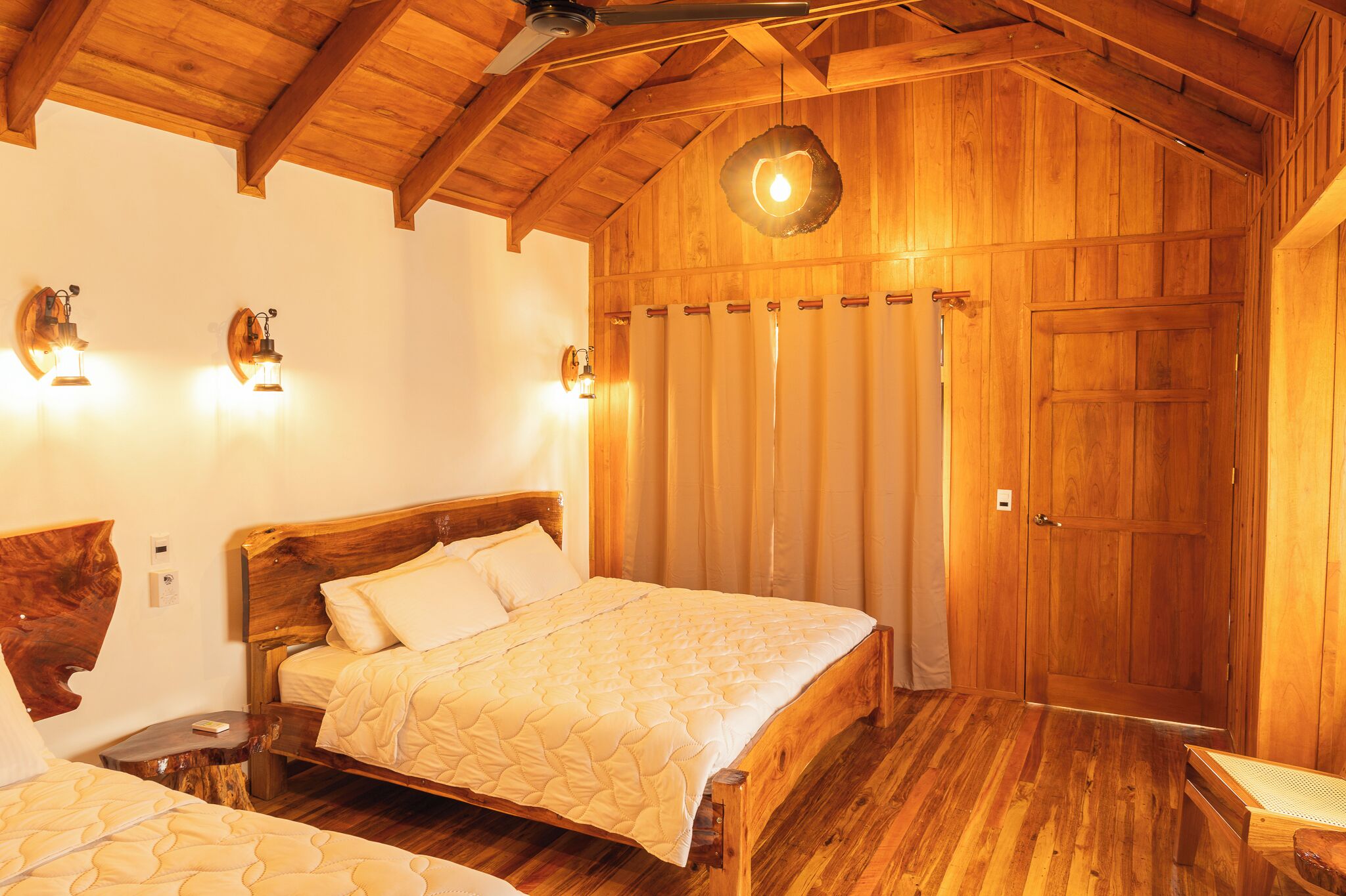 Quarto de madeira com uma cama grande, uma mesa de cabeceira e cabeceira de madeira.
