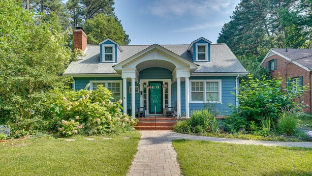 A two-story house with a front porch, brick pathway, and a well-maintained garden. - 2 Mi to Duke University: Durham Tiny Home! (Durham)