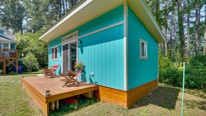A turquoise house with a wooden deck, two lounge chairs, and a small garden area. - 2 Mi to Duke University: Durham Tiny Home! (Durham)