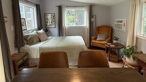 A bedroom with a bed, two chairs, a table, a ceiling fan, and a window with curtains. - 2 Mi to Duke University: Durham Tiny Home! (Durham)