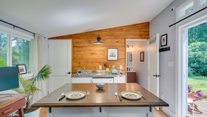 A modern kitchen with wooden accents, a dining table set for two, and a view of the outdoors. - 2 Mi to Duke University: Durham Tiny Home! (Durham)