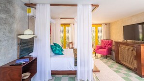 Quarto com cama, televisão, cadeira e armário de madeira.