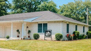 A single-story brick building with a covered porch and a sign reading "Sisters Four." - Sisters Four Bed and Bath - Luxury living in a small town atmosphere!   (Centralia)
