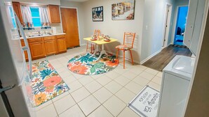 A compact kitchen with wooden cabinets, a dining table with chairs, and a refrigerator. - Sisters Four Bed and Bath - Luxury living in a small town atmosphere!   (Centralia)