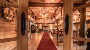 A wooden interior with a red carpet leading to a dining area. - Jela Natural Resort (Rozaje)