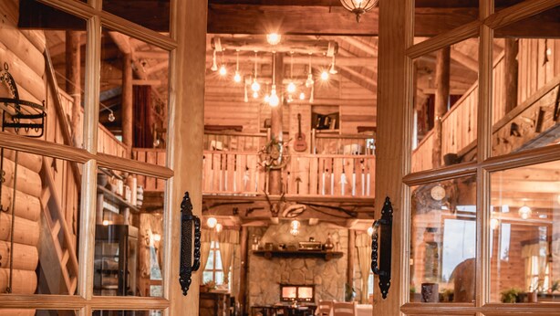 A wooden interior with a red carpet leading to a dining area. - Jela Natural Resort (Rozaje)
