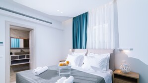 A modern hotel room with a neatly made bed, a bedside table with a lamp, and a built-in wardrobe. - Villa Luna 1 with swimming pool in Pitsidia (Pitsidia)
