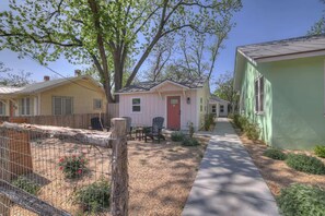 A row of single-story houses with a fenced yard and a pathway. - The Grove B Stylish Cottage - Walk to Main (Fredericksburg)