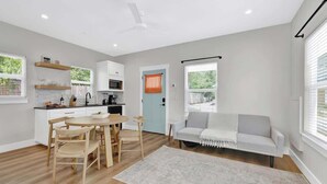 A modern apartment with a kitchen, dining area, and living room. - The Grove-c With Hot Tub - Walk to Main Street (Fredericksburg)