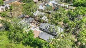 An aerial view of a residential area with houses, trees, and a clear sky. - The Grove-c With Hot Tub - Walk to Main Street (Fredericksburg)