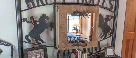 A rustic metal sign with 'HAPPY TRAILS' and silhouettes of horses.