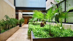 A modern indoor garden with various plants and a tiled floor. - Kuxtal 3 Bedroom Downtown Apartment  (Playa del Carmen)