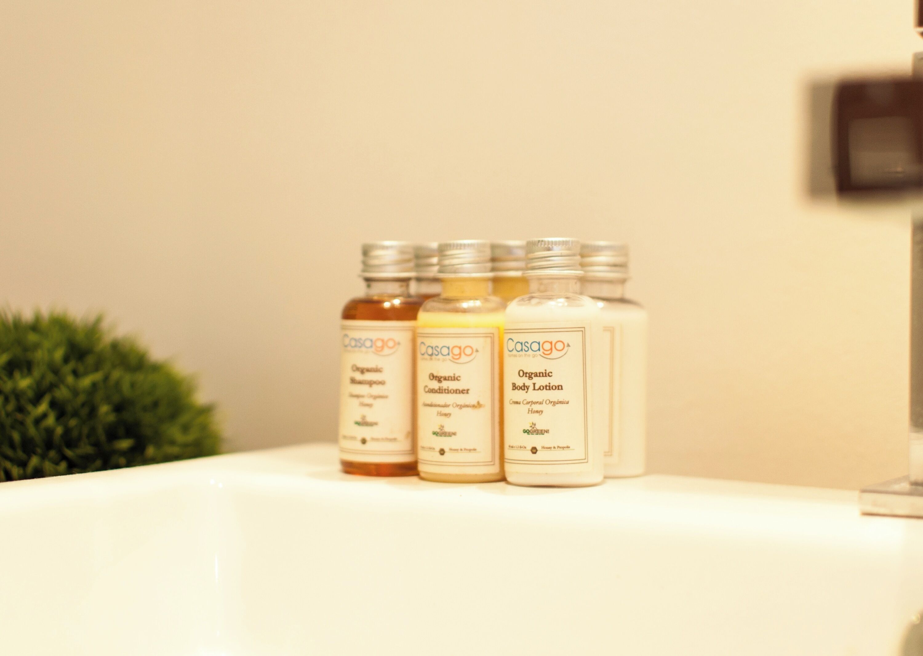 Three bottles of Casago organic products on a white surface.