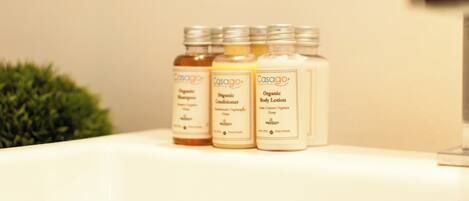 Three bottles of Casago organic products on a white surface.
