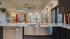 A modern kitchen with a dishwasher, stainless steel sink, and dark cabinets. - Magical Condo in Midtown! (Oklahoma City)