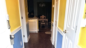 A hallway with a patterned rug, wooden flooring, and doors leading to a dining area. - Gorgeous 1st Floor Condo at Arrowhead Country Club
 (Myrtle Beach)