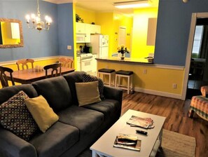 Cozy living space with a dining area and kitchenette, featuring a sofa, coffee table, and dining table.