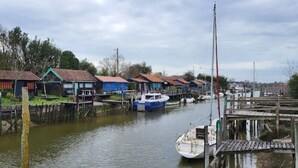 Ein Flussdorf mit Holzhäusern und Booten, die am Ufer liegen.