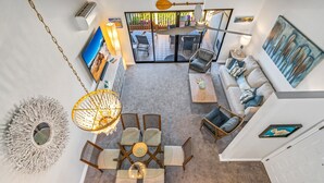 A spacious living area with a round coffee table, a sofa, and a dining set. - Luxurious & Spacious Ocean Vistas (Kihei)