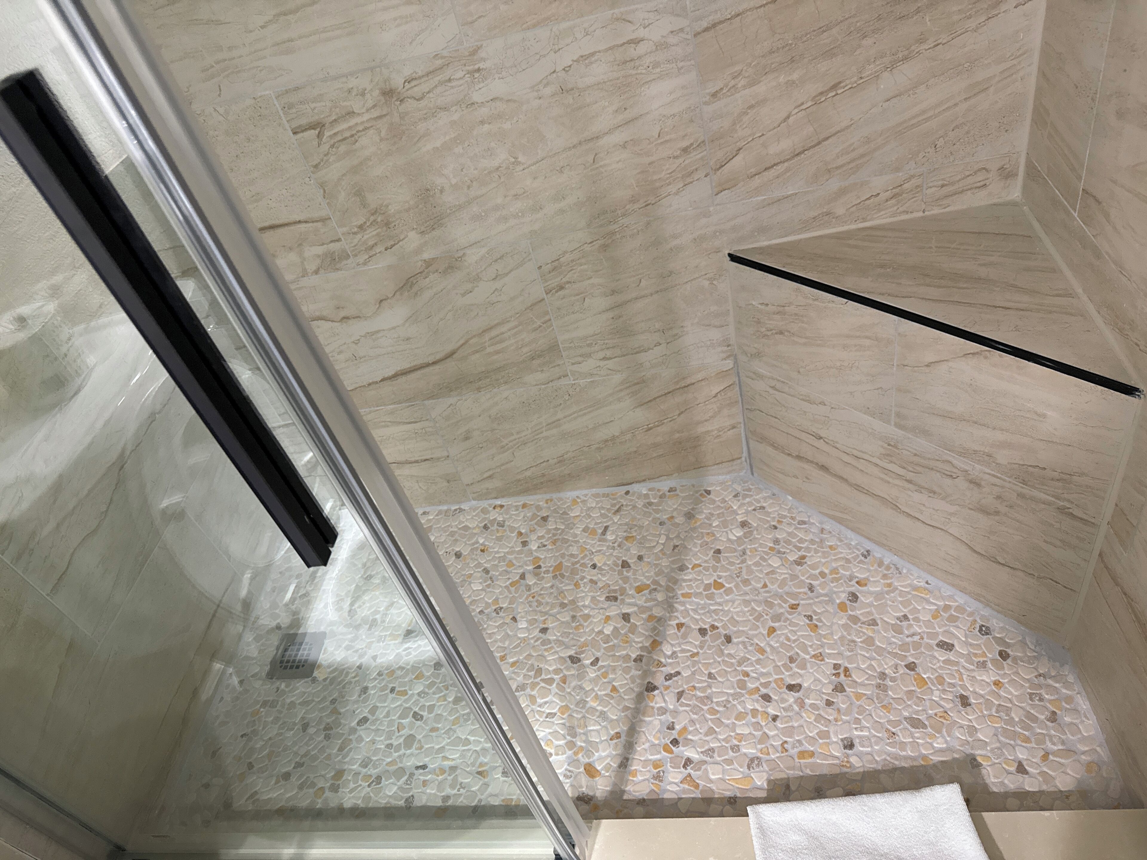 Une douche entièrementClose avec des parois en verre, un sol carrelé et un mur en marbre.