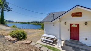 A small white building with a red door, labeled "Vista Hermosa," featuring a picnic table and steps leading to the entrance. - Peaceful Cloverdale Home - Walk to Winema Beach (Cloverdale)
