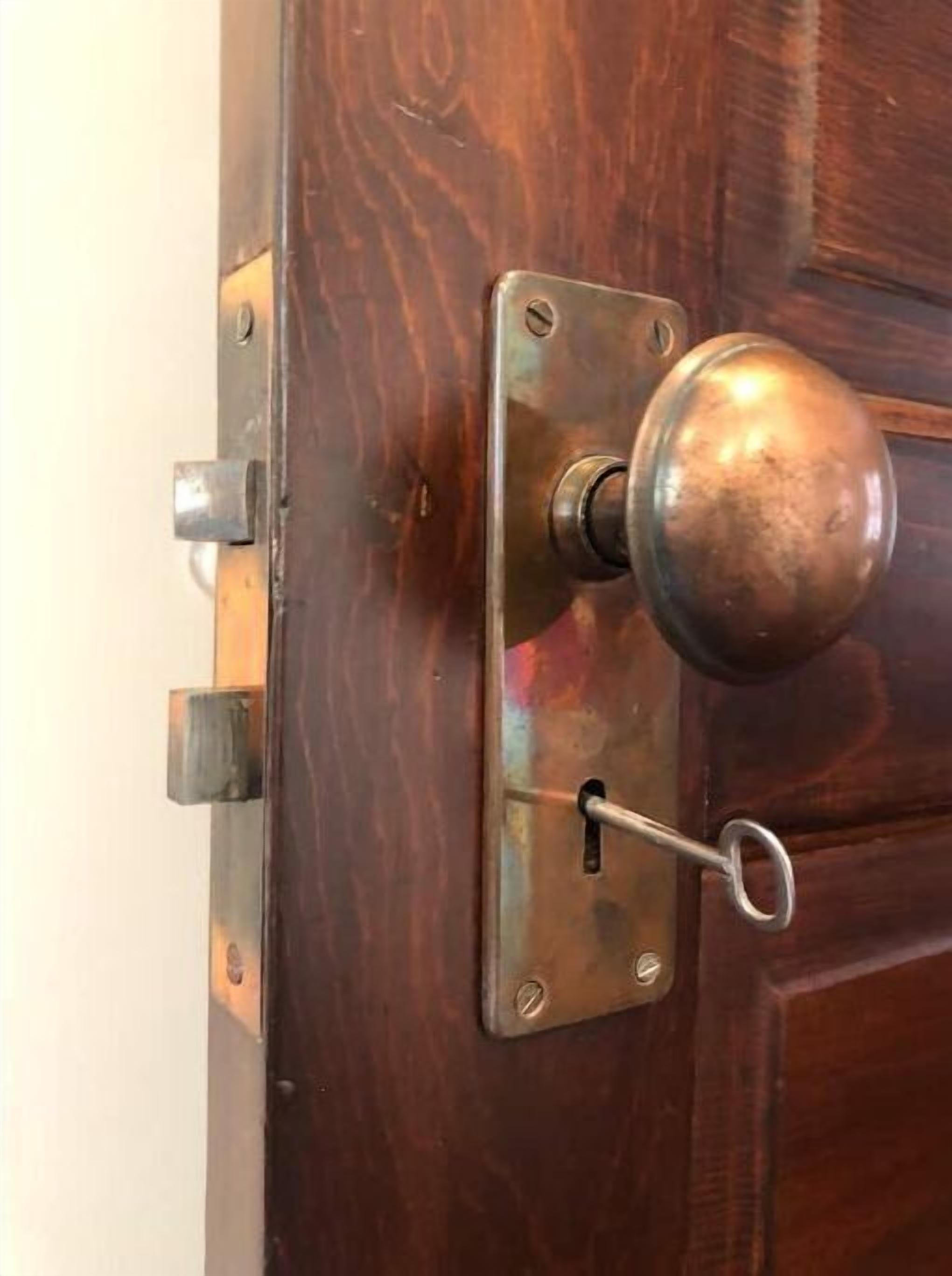 Une porte en bois avec une poignée de porte en laiton et un trou de serrure.