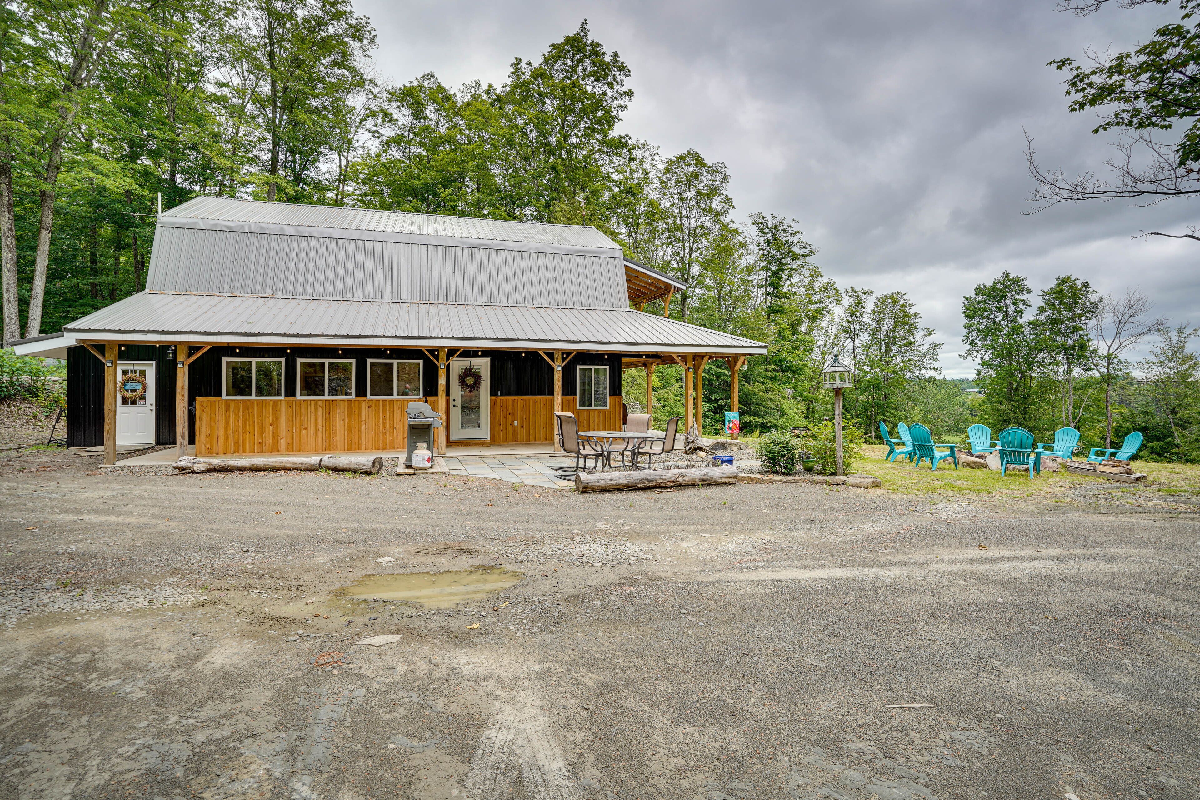 A rustic cabin with a porch, a table, and chairs outside.