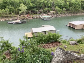 A lakeside property with a dock, a small building, and a large shed.